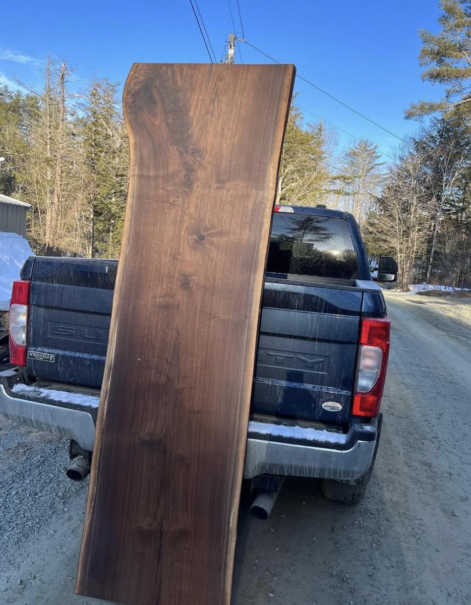 Long dark slab standing beside a pickup truck