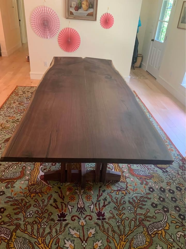 Finished dark live edge hardwood slab used as a dining surface